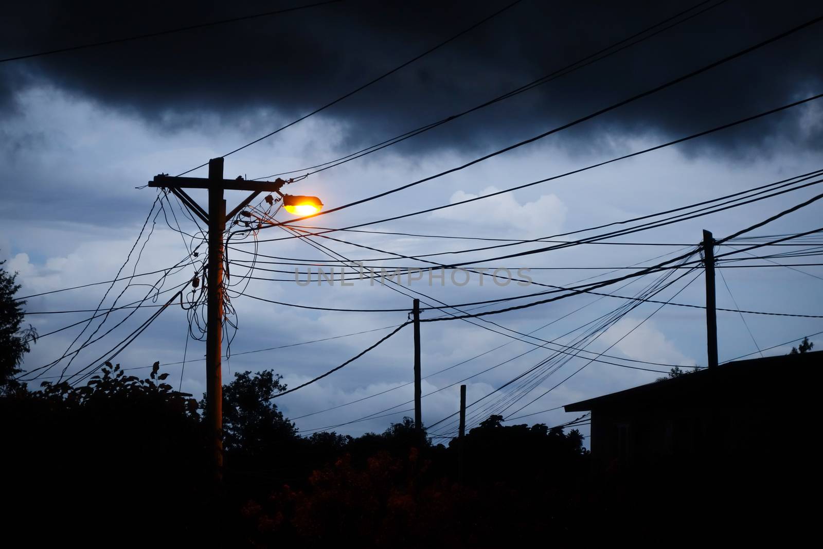 Street light at night with a stormy sky background. Dark mystery scene