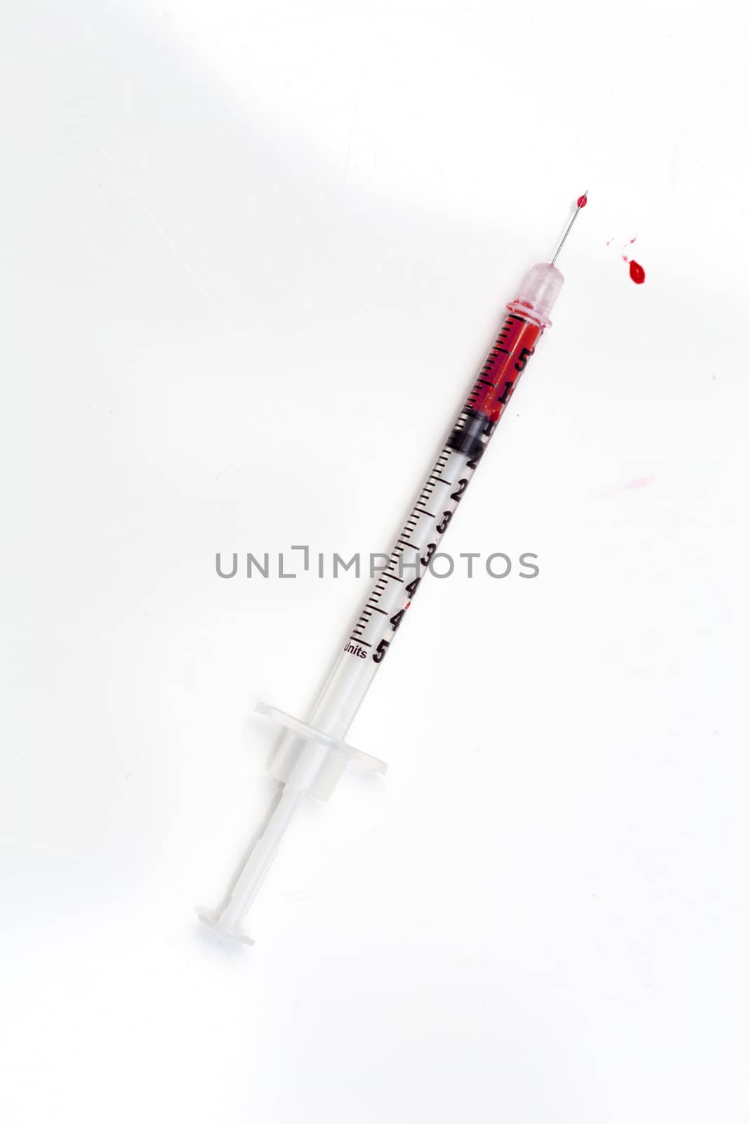 Blood-filled syringe on white background