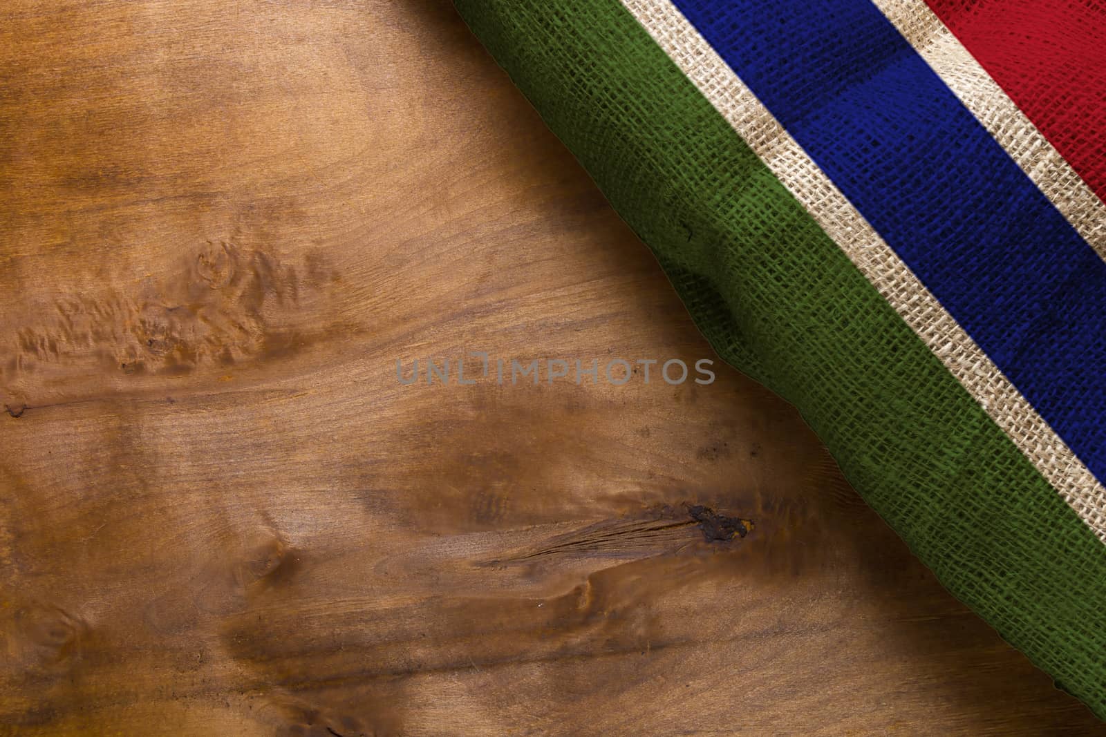 National flag of the country Gambia on a wooden background.