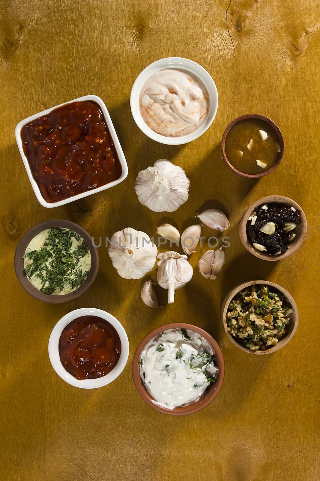 Various sauces with garlic on a wooden surface