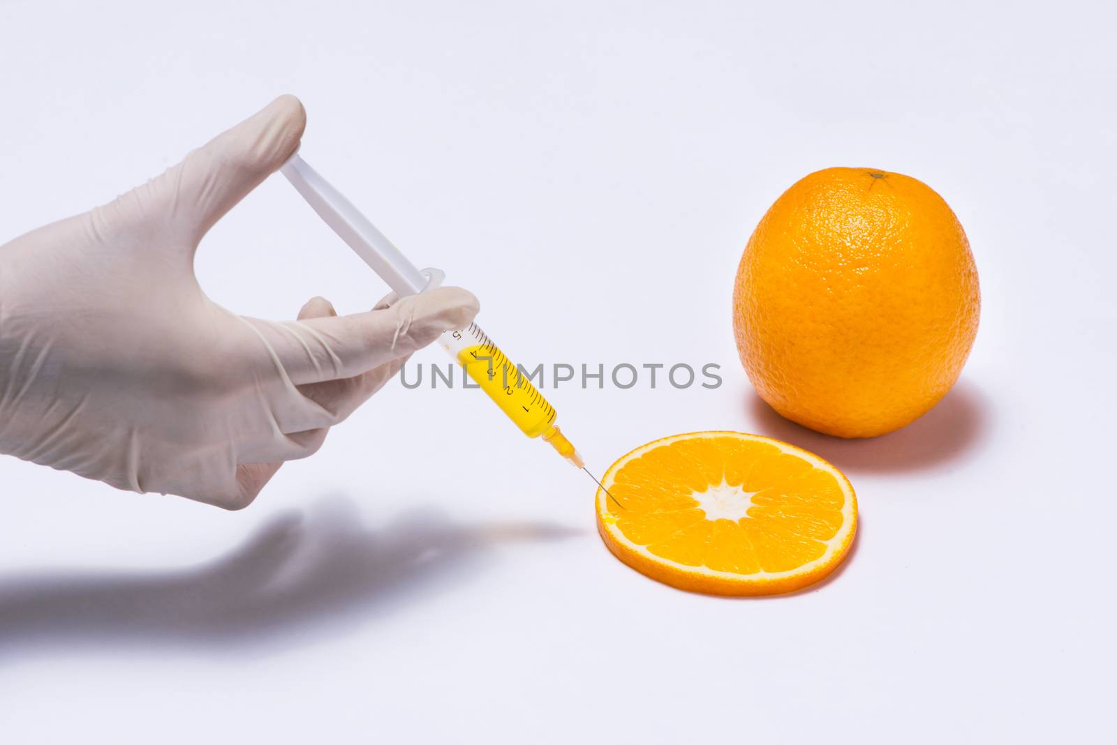 Science experiment with orange and syringe isolated on white. by makidotvn