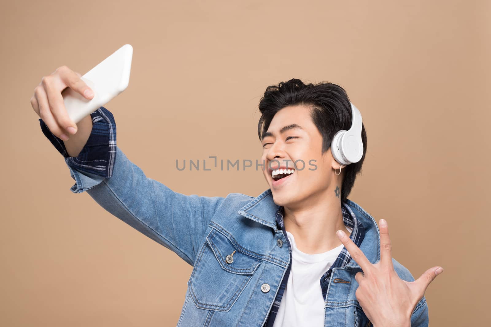 Portrait of a young asian handsome man with headphones smiling a by makidotvn
