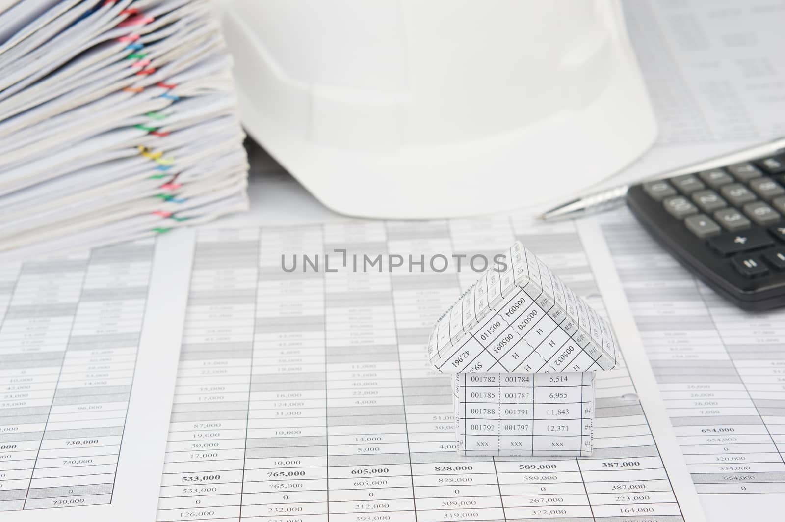 House with blur white engineer hat and pile overload document by eaglesky