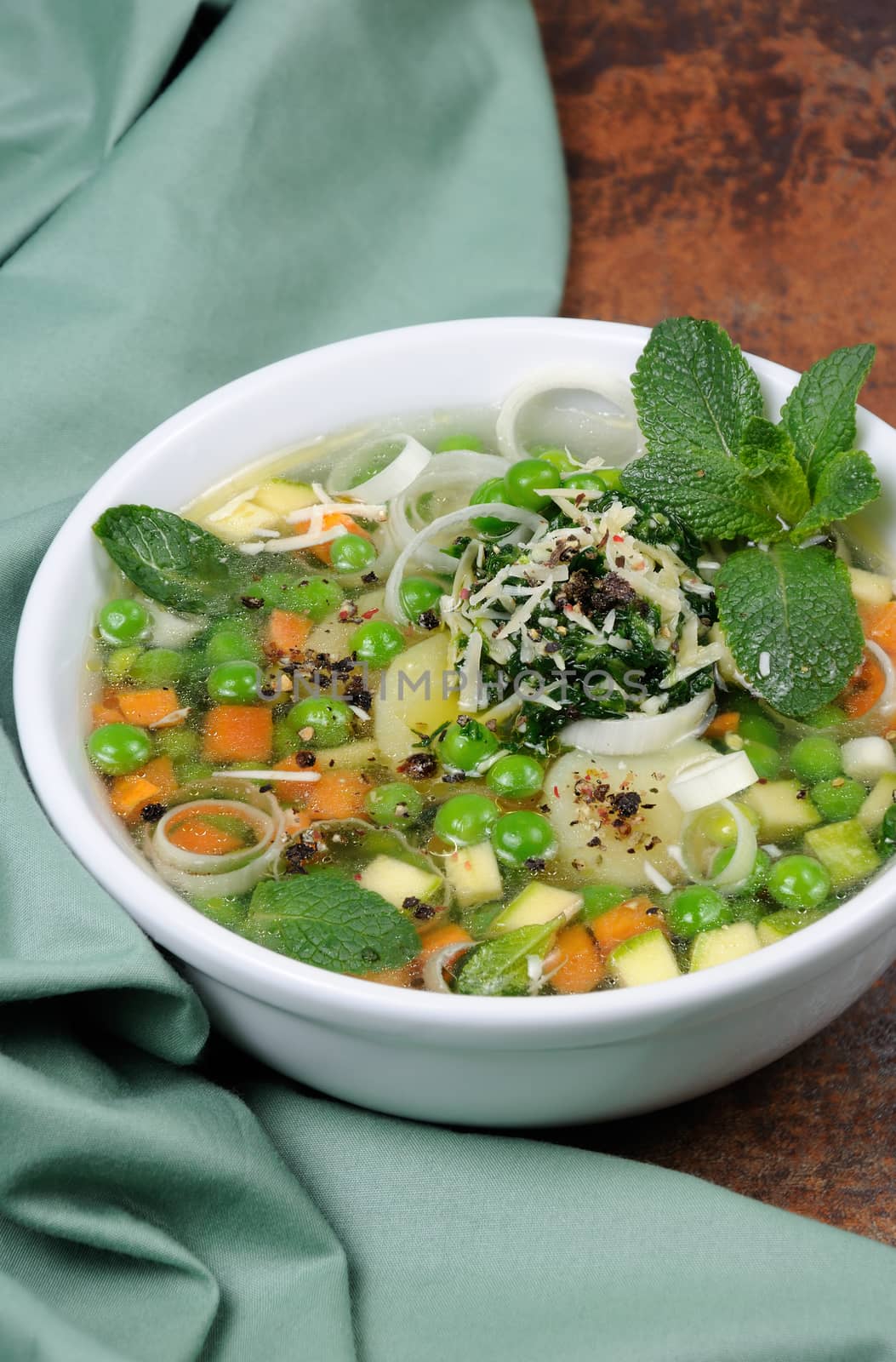 Light, refreshing soup of carrots, zucchini, potatoes, leeks, peas, pesto, parmesan and mint leaves.