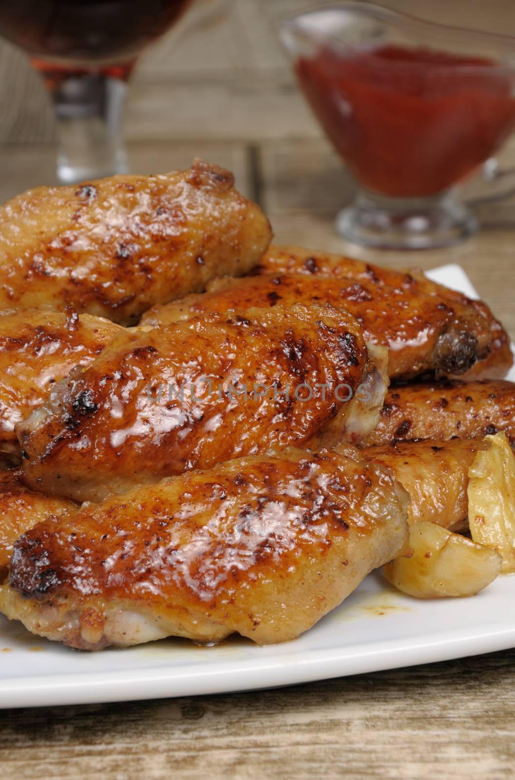 Fried sharply spicy chicken wings on a baking c sauce