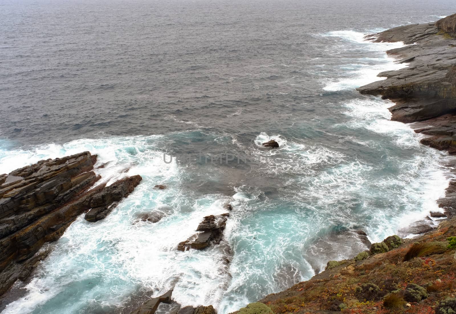 Rock and waves on the sea at rainy day.