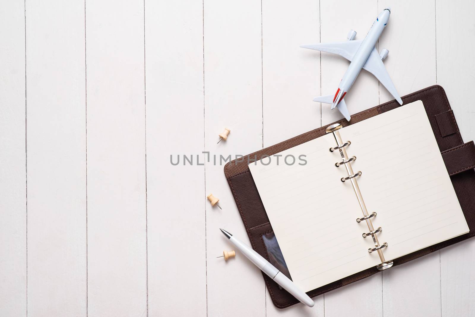 Business trip concept. Airplane and blank open notebook for your text.