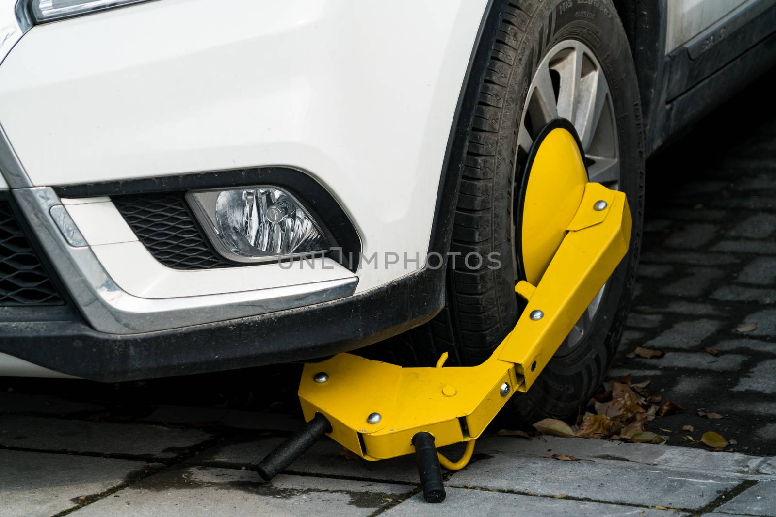 A car parks on forbidden parking lot, being wheel clamp lock