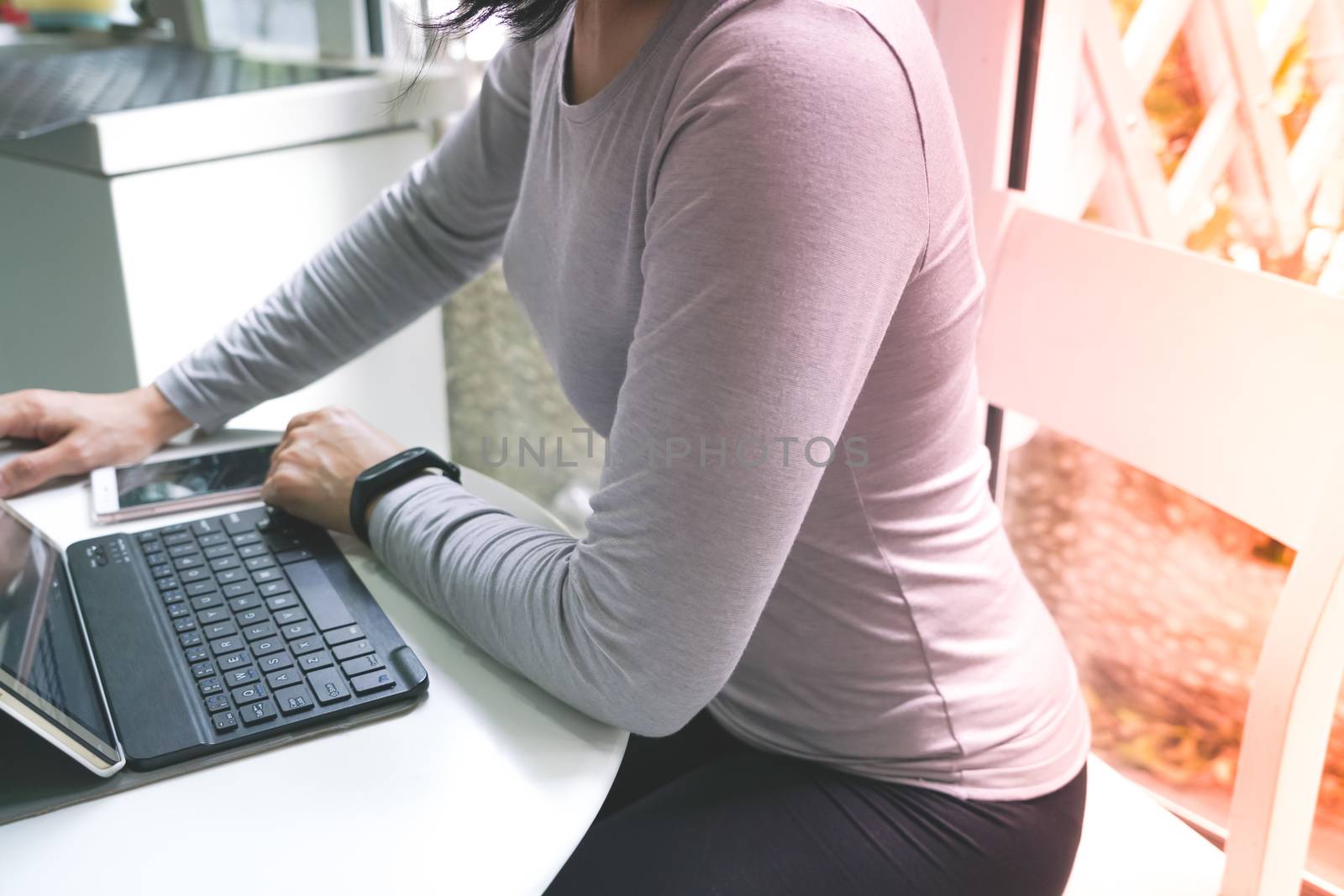 Young student women wearing smart band focus on her tablet compu by psodaz