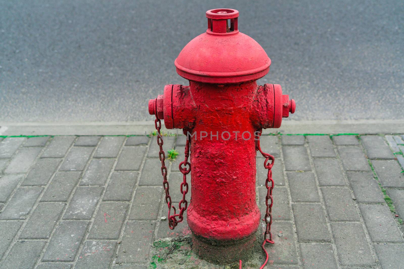 Red fire water hydrant beside the road by psodaz