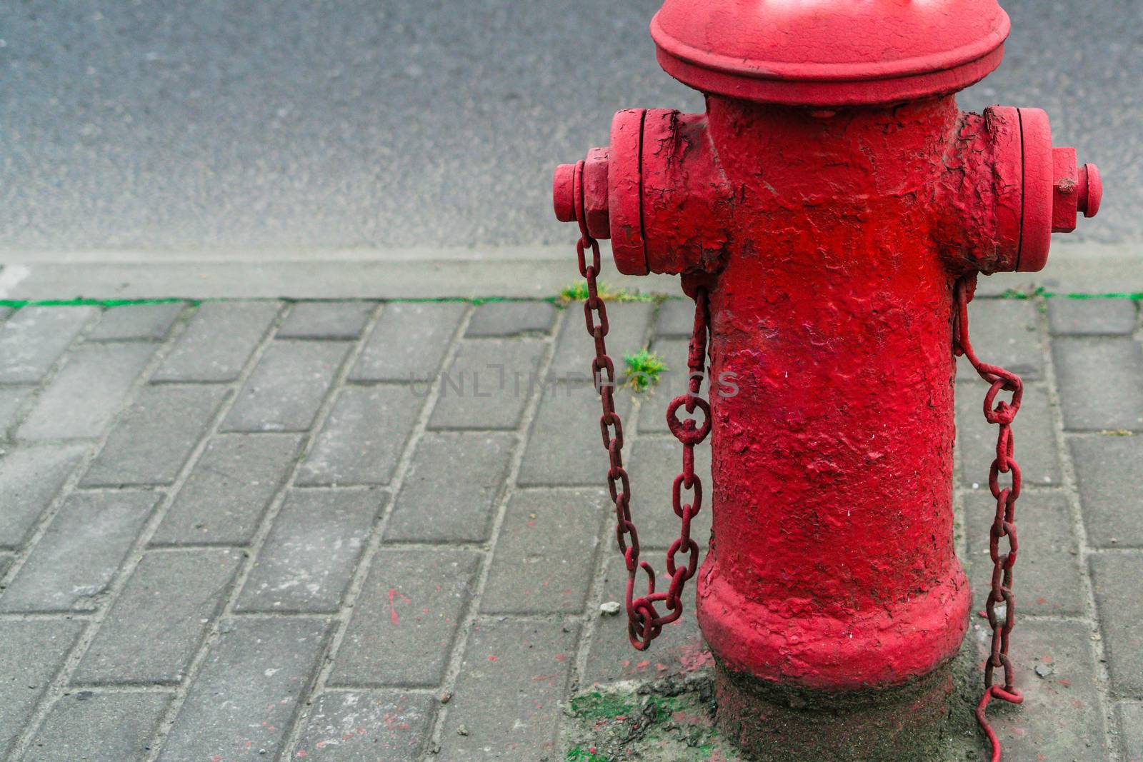 Red fire water hydrant beside the road by psodaz