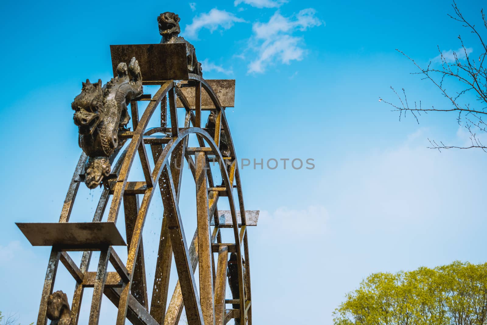 Ancient steel watermill wheel, Chinese style with blue sky backg by psodaz