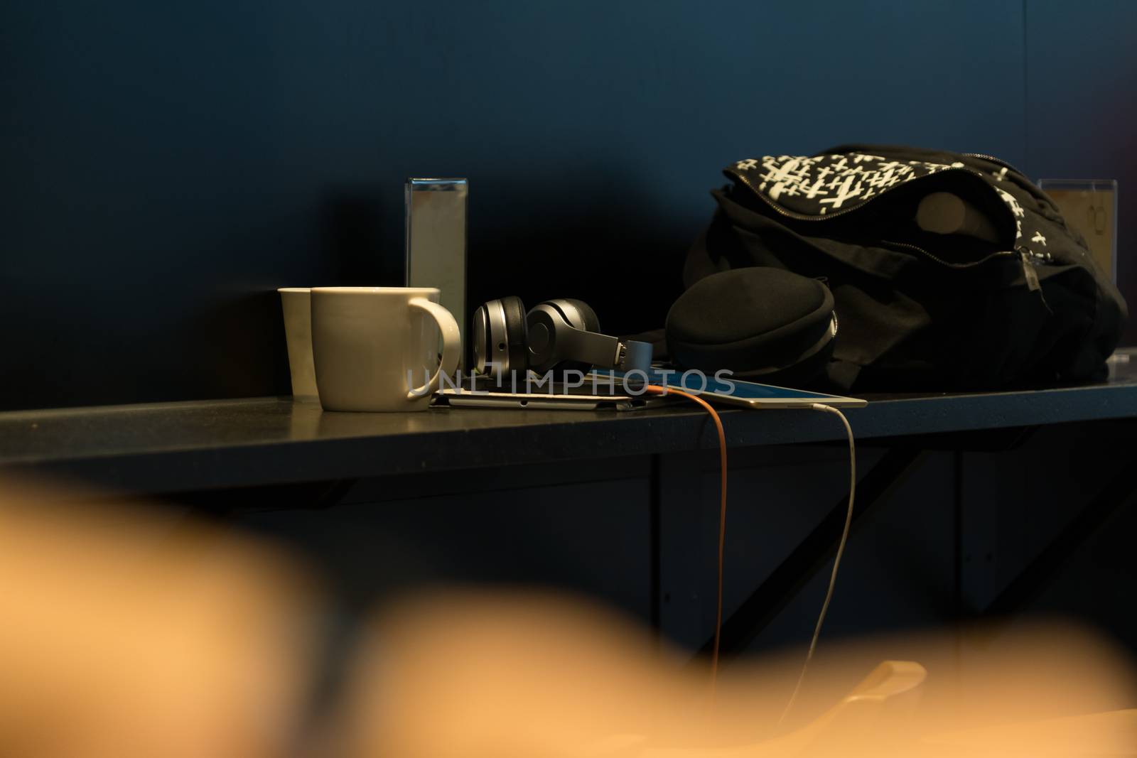 Gadgets and white cup on a coffee bar