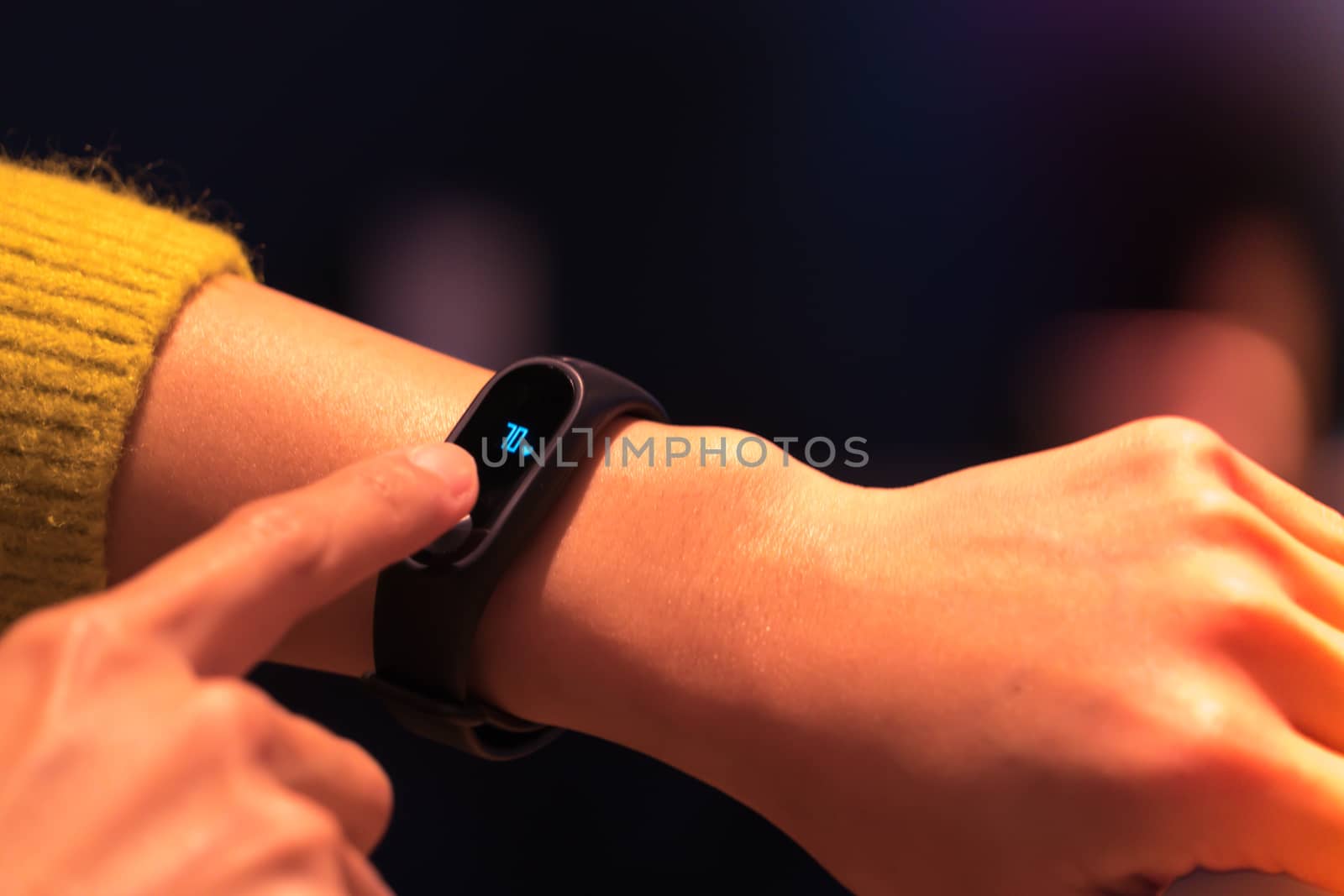 Women touching fitness smart band on her hand by psodaz