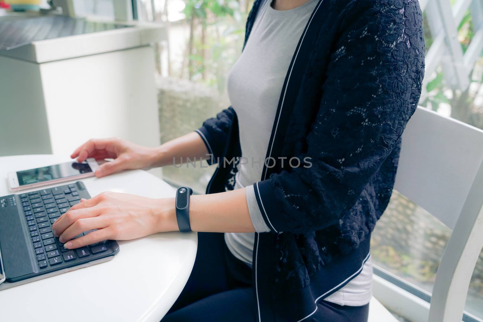 Young student women wearing smart band touching tablet computer and smart phone