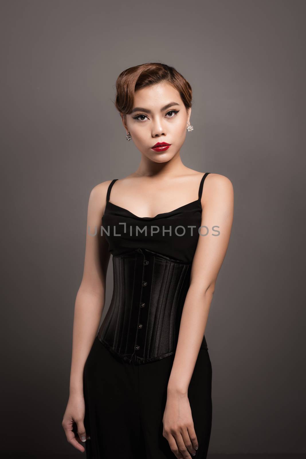 Sexy attractive asian woman posing in fashionable black dress ov by makidotvn