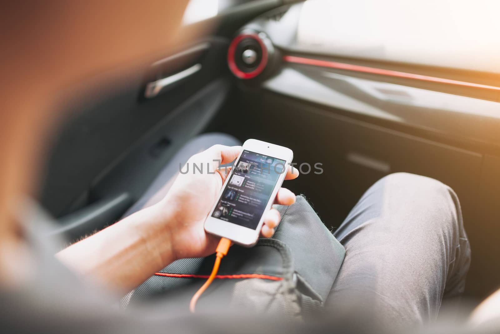 Man connecting phone to the car media system by nopparats