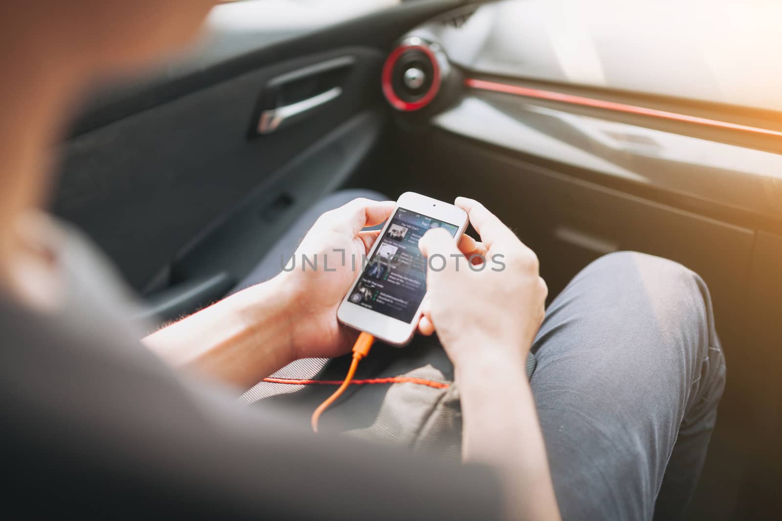 Man connecting phone to the car media system by nopparats