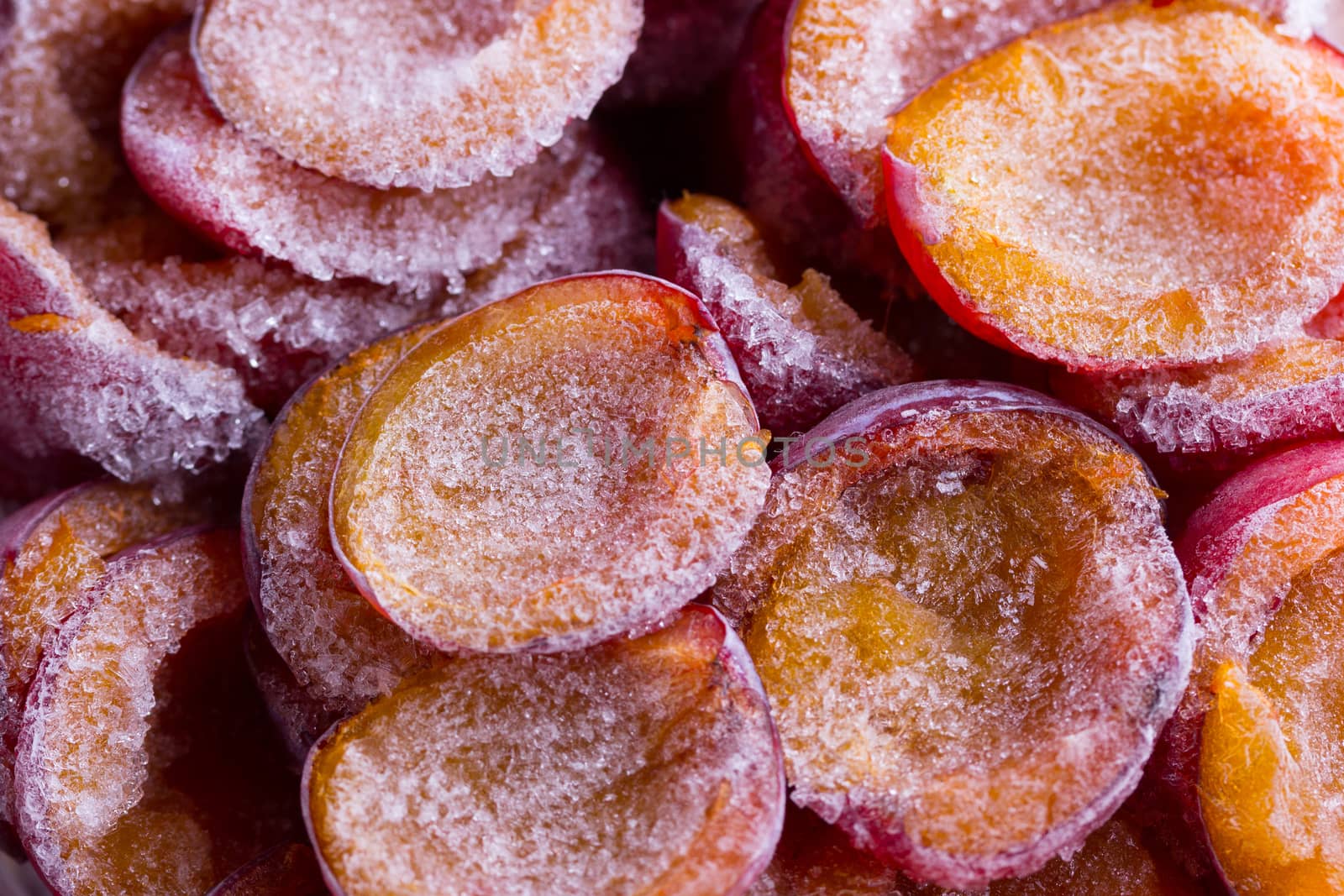 frozen half of a plum on a wooden background. Winter vitamins