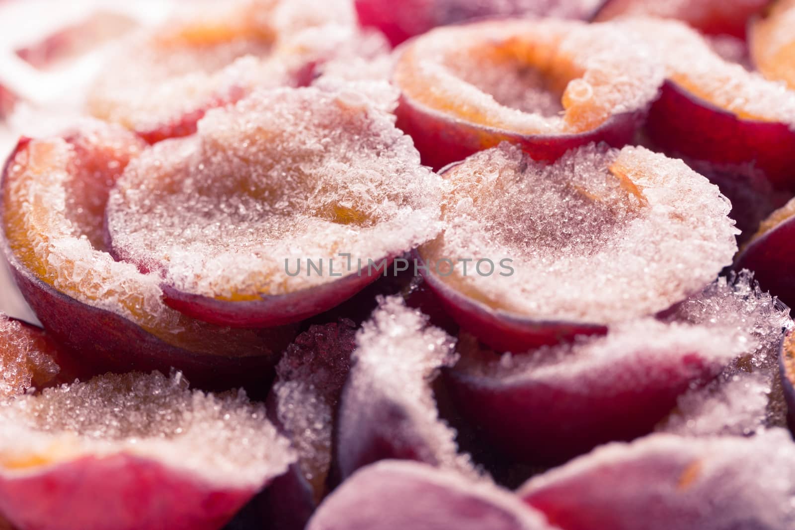frozen half of a plum on a wooden background. Winter vitamins