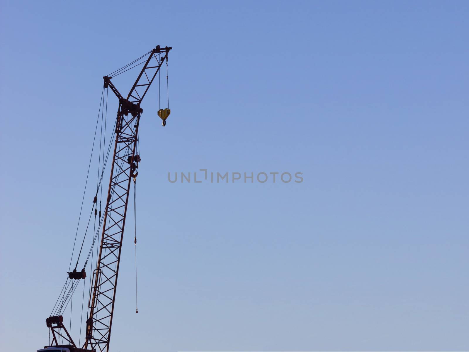 yellow construction crane on blue sky background