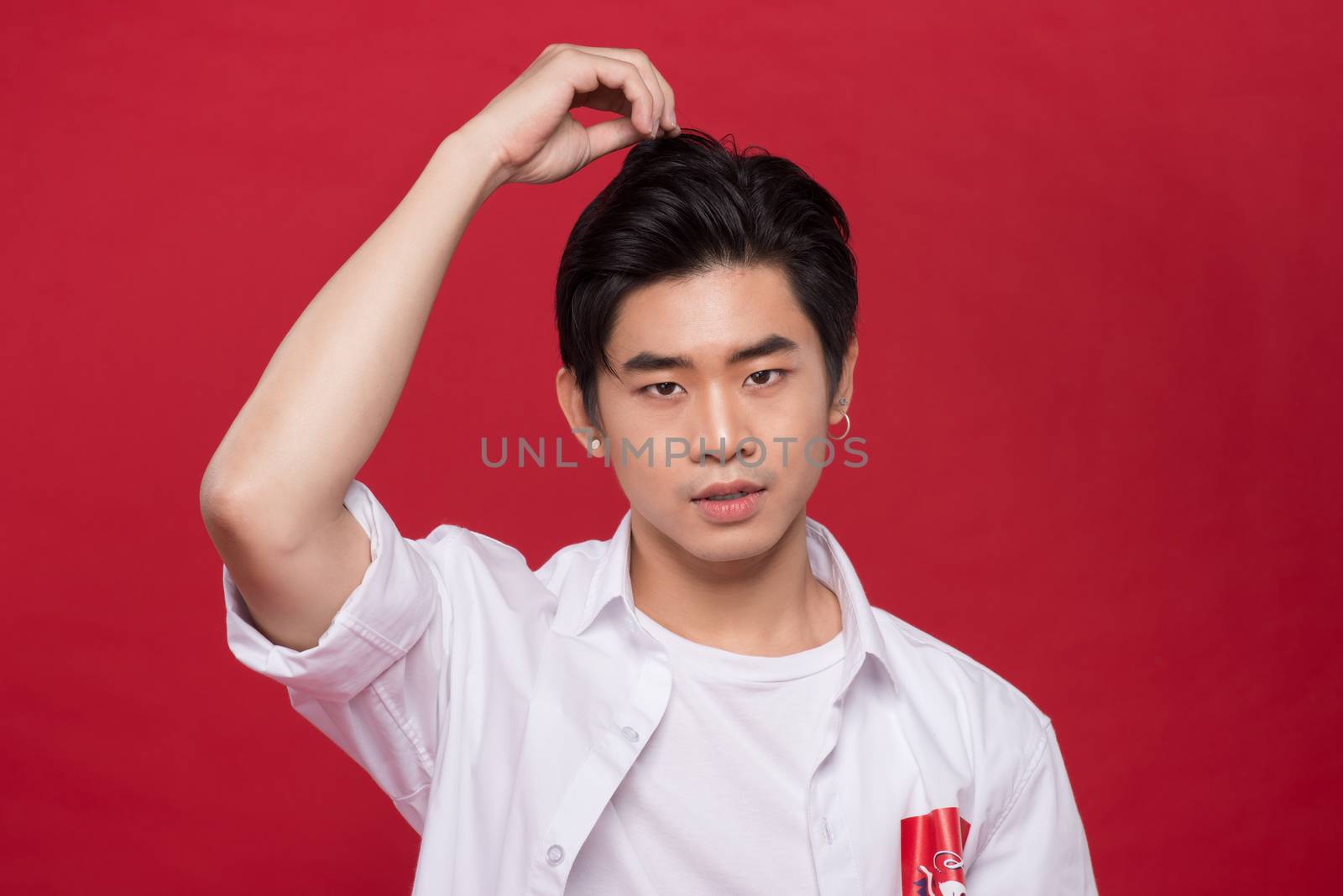 Portrait of elegant young handsome asian man over red background. Cool fashion male model.