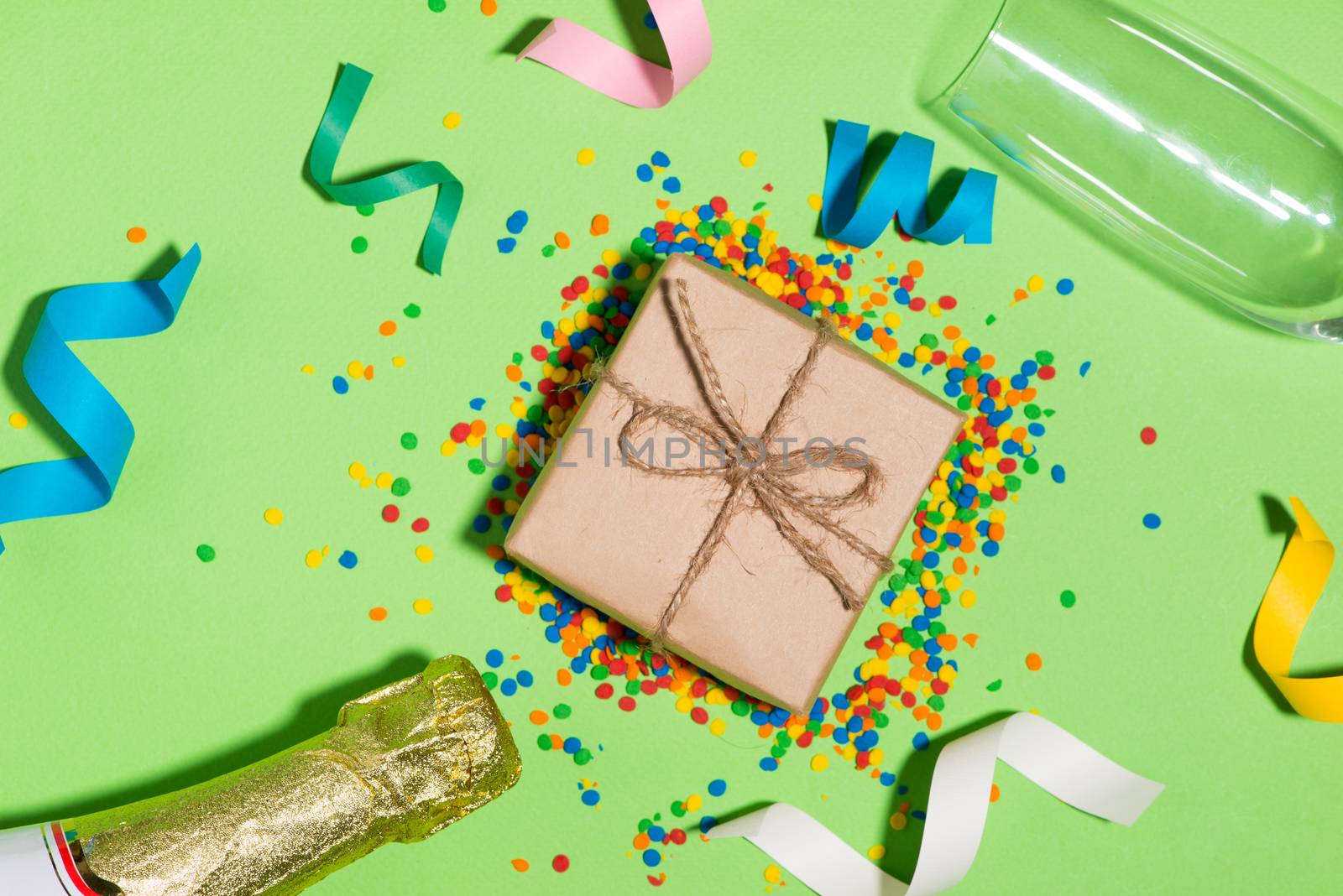 Celebration Flat lay. Gift box with colorful party items on green background.