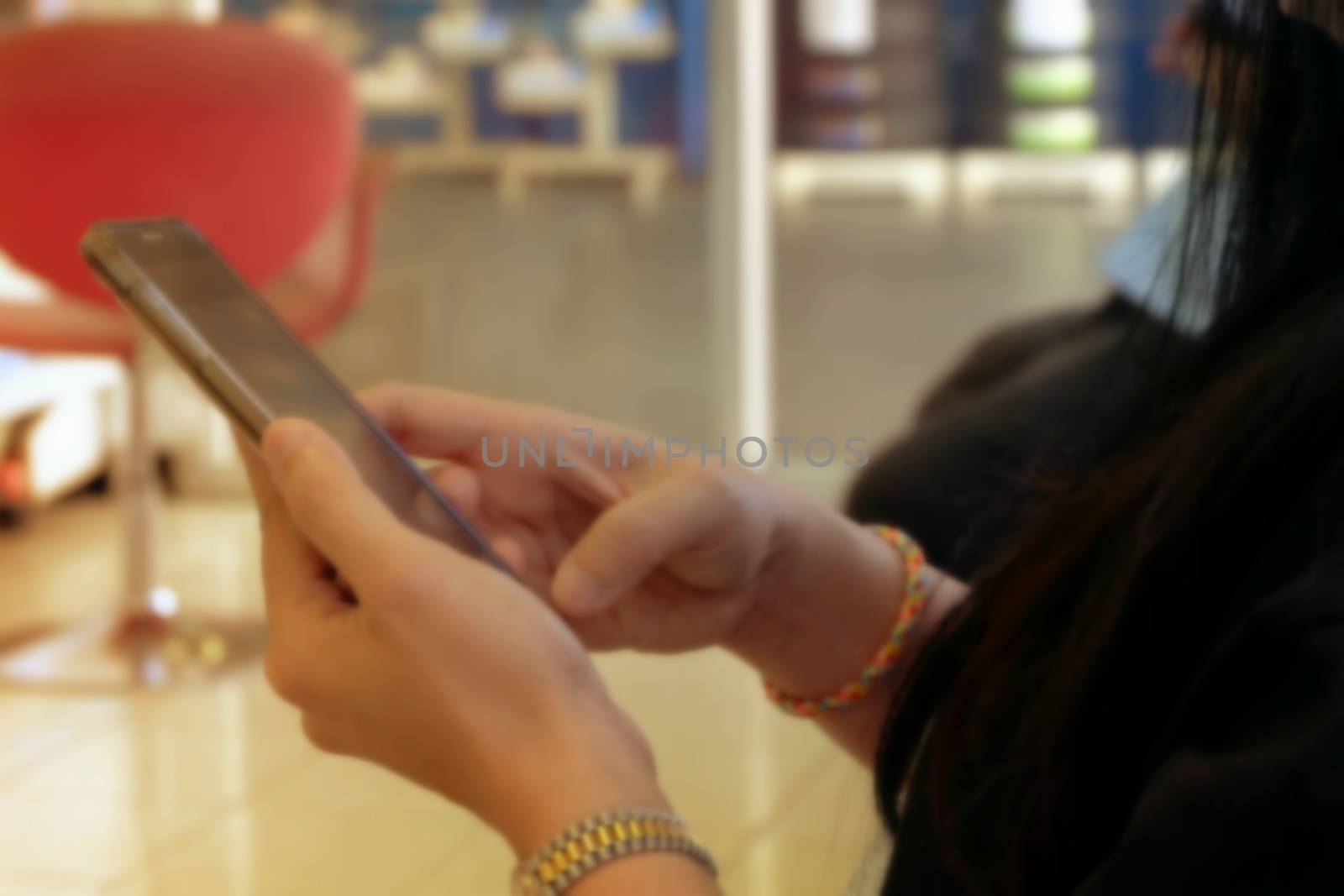 Blurred of Woman Hand Playing Mobile Phone.
