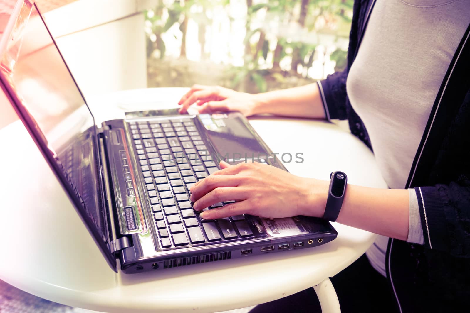 Young student women wearing smart band using laptop computer