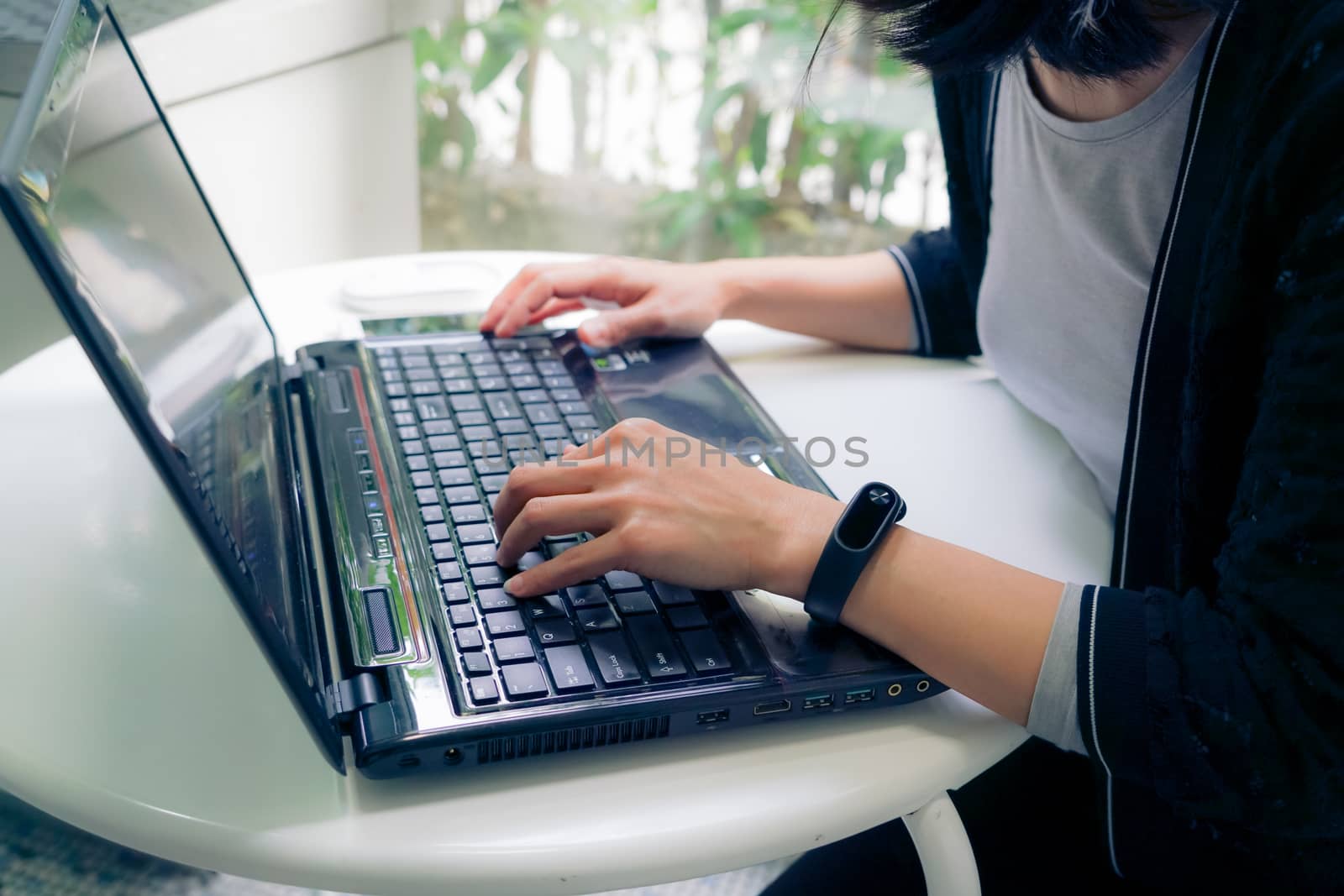 Young student women wearing smart band focus on her laptop compu by psodaz