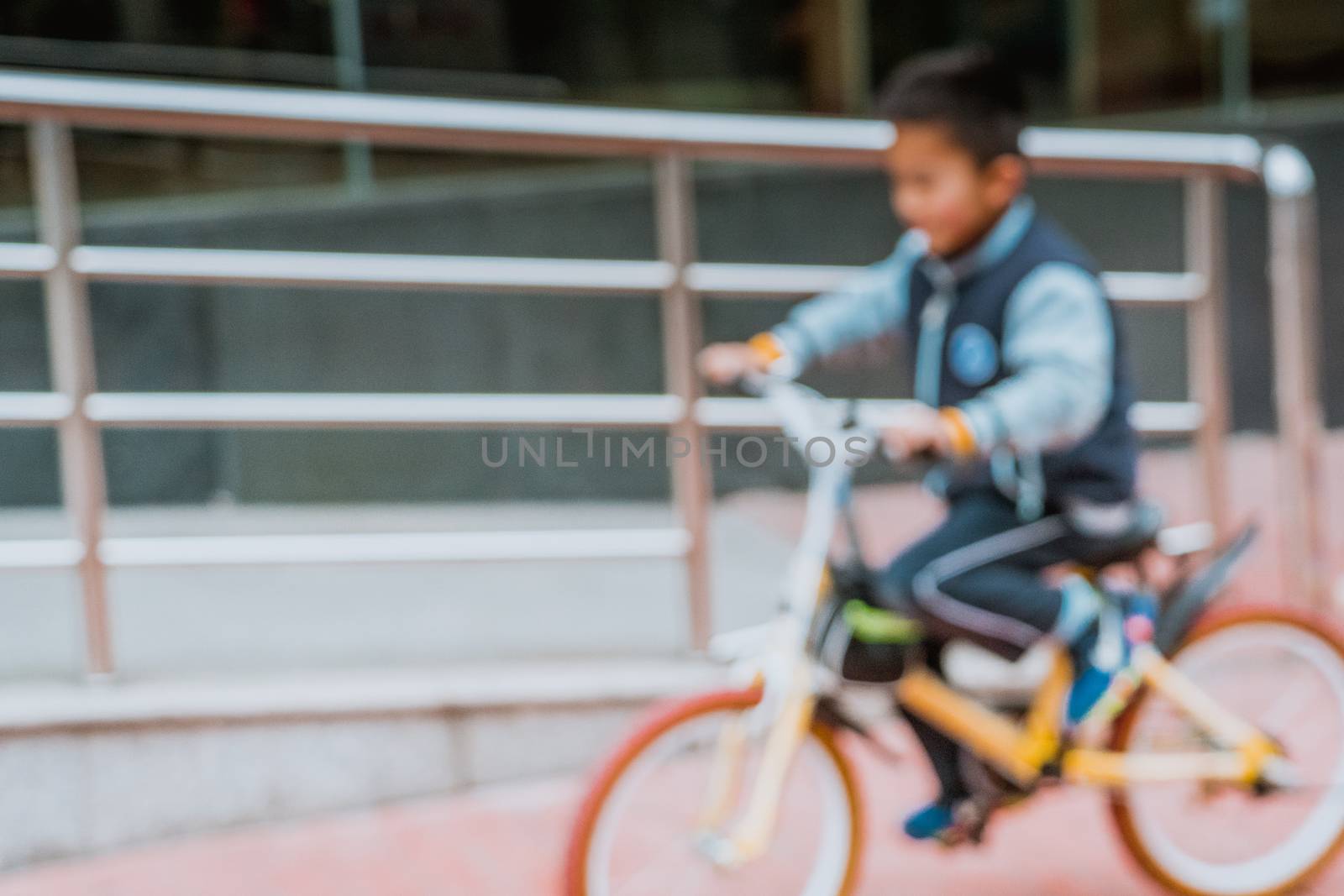 Blurred photo of asian boy riding bicycle in winter season by psodaz