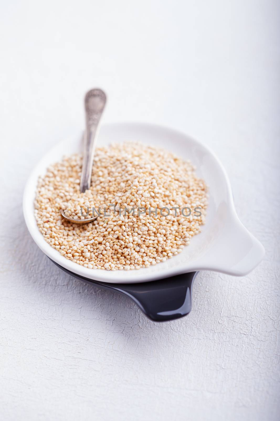 Raw quinoa on wooden table by supercat67