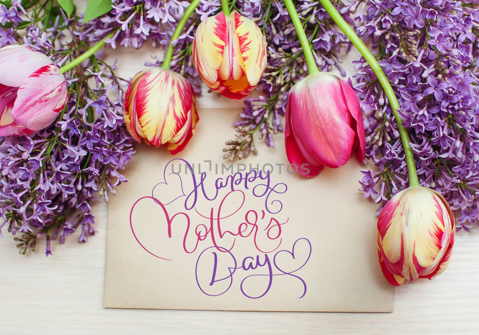 frame from tulips and lilac and text Happy mothers day. Calligraphy lettering hand draw.