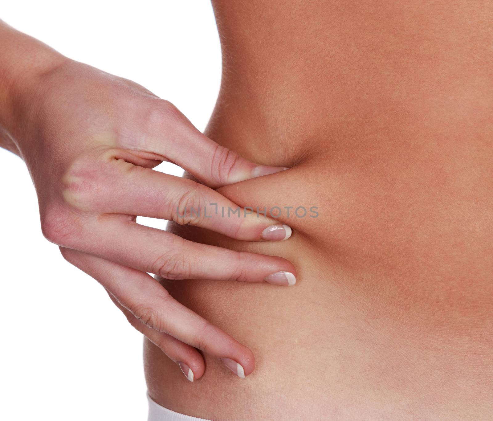 Woman pinches fat on her belly, isolated on white background
