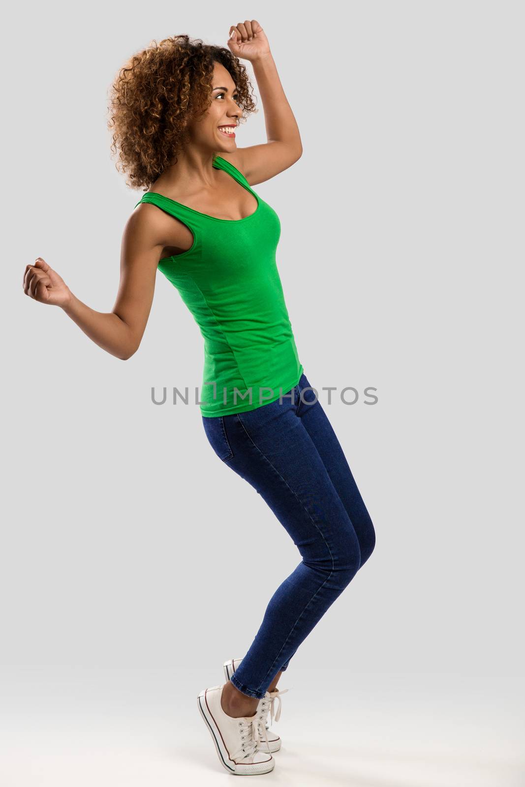 Beautiful and happy African American woman with arms raiaed