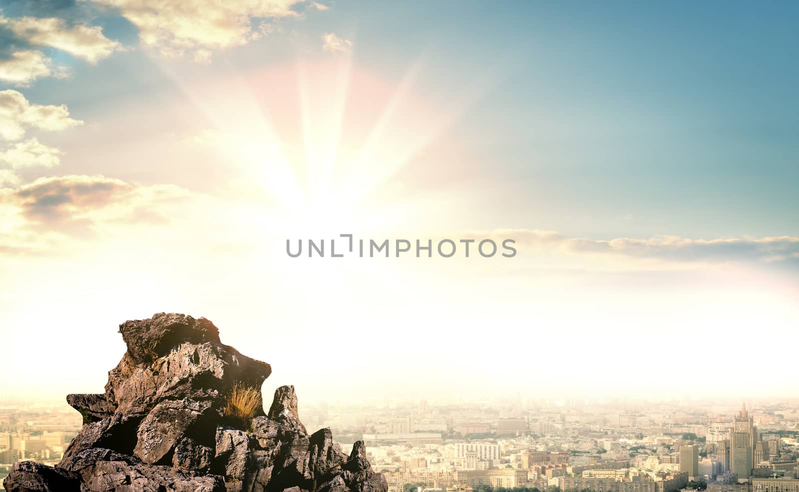Stone mountain in the background of the city and sunrise. Background for your design. On the mountain an empty space for your content