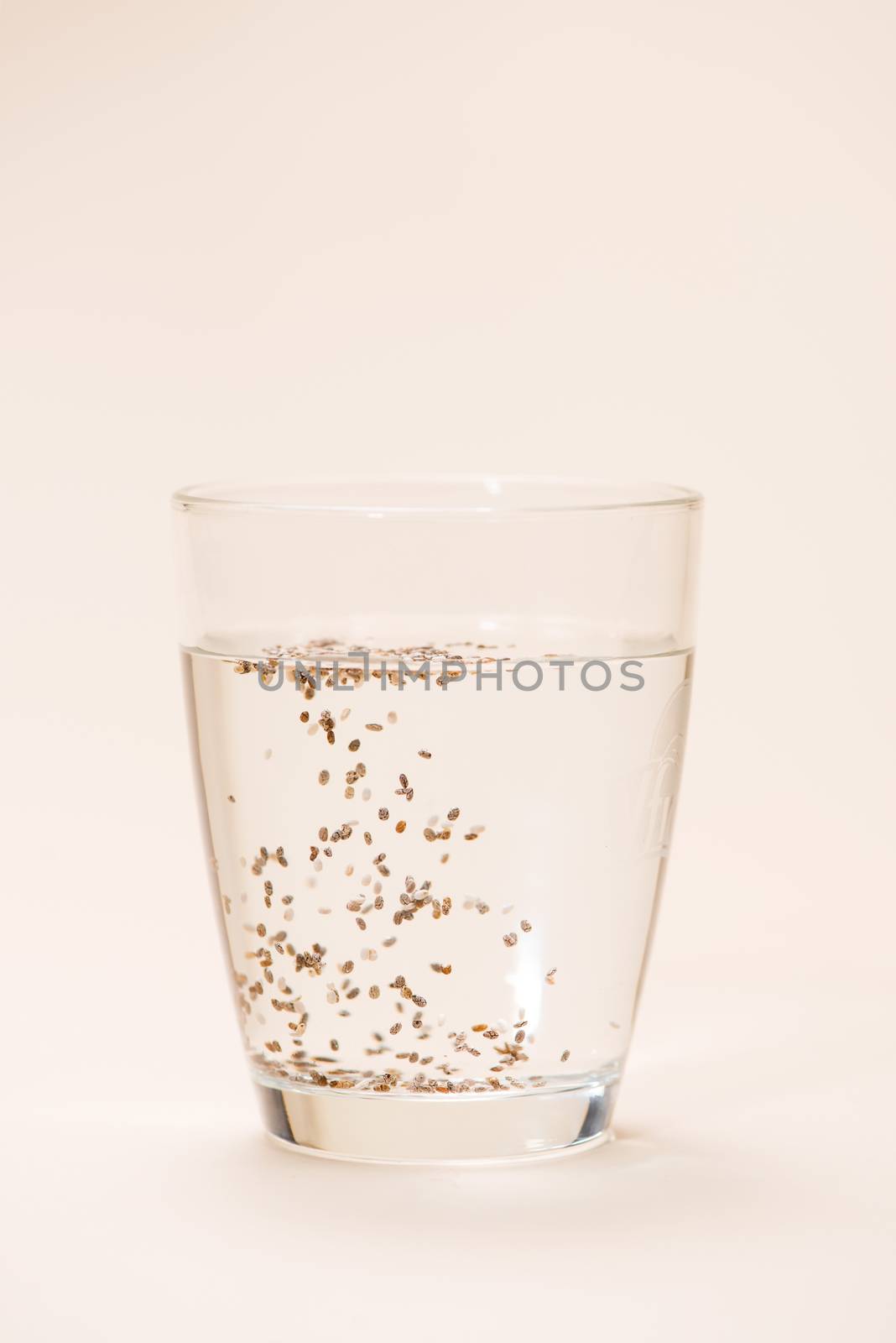 Glass of water with cup of healthy chia seeds and spoon. Text sp by makidotvn