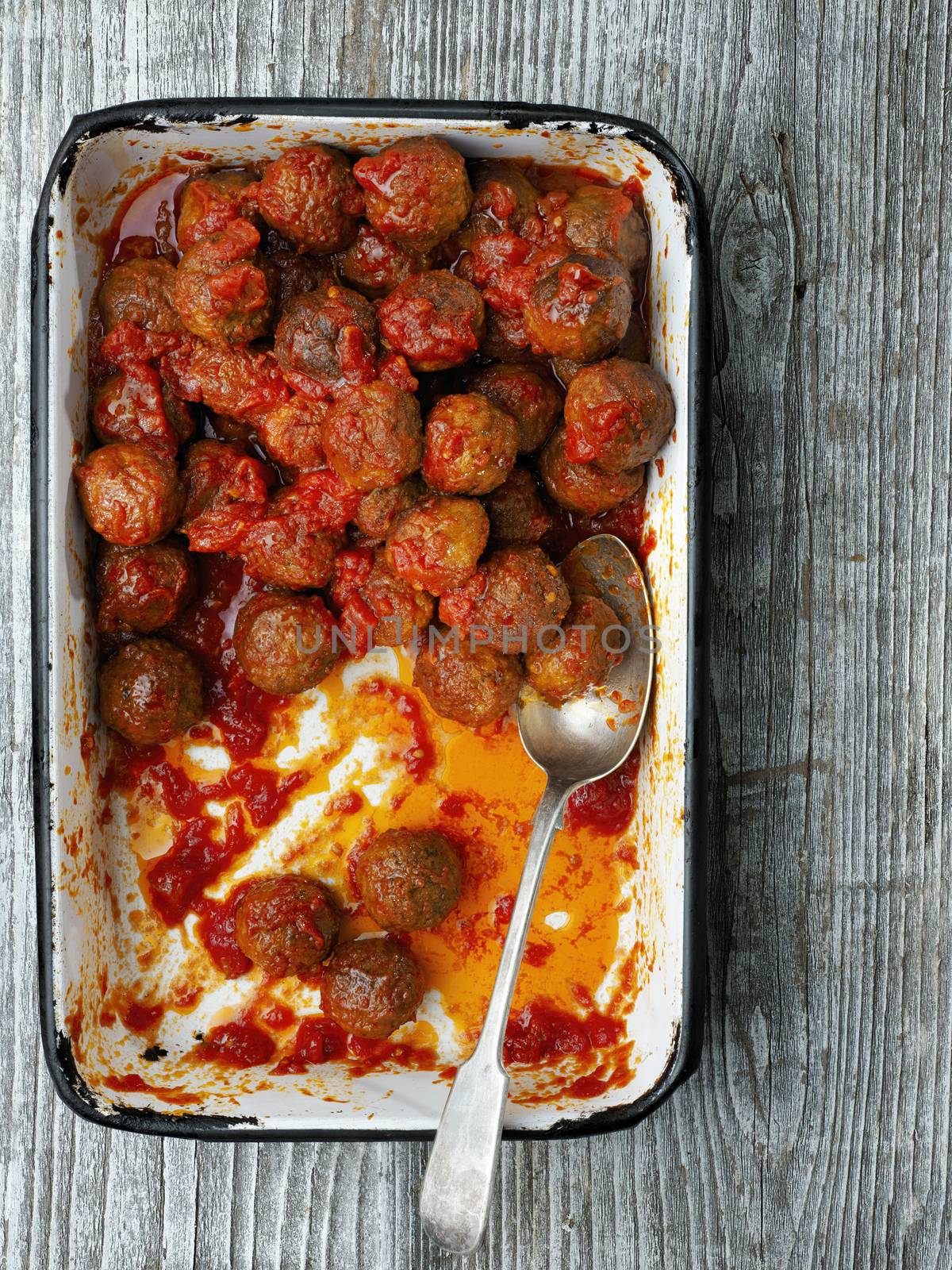 close up of rustic italian meatball in tomato sauce