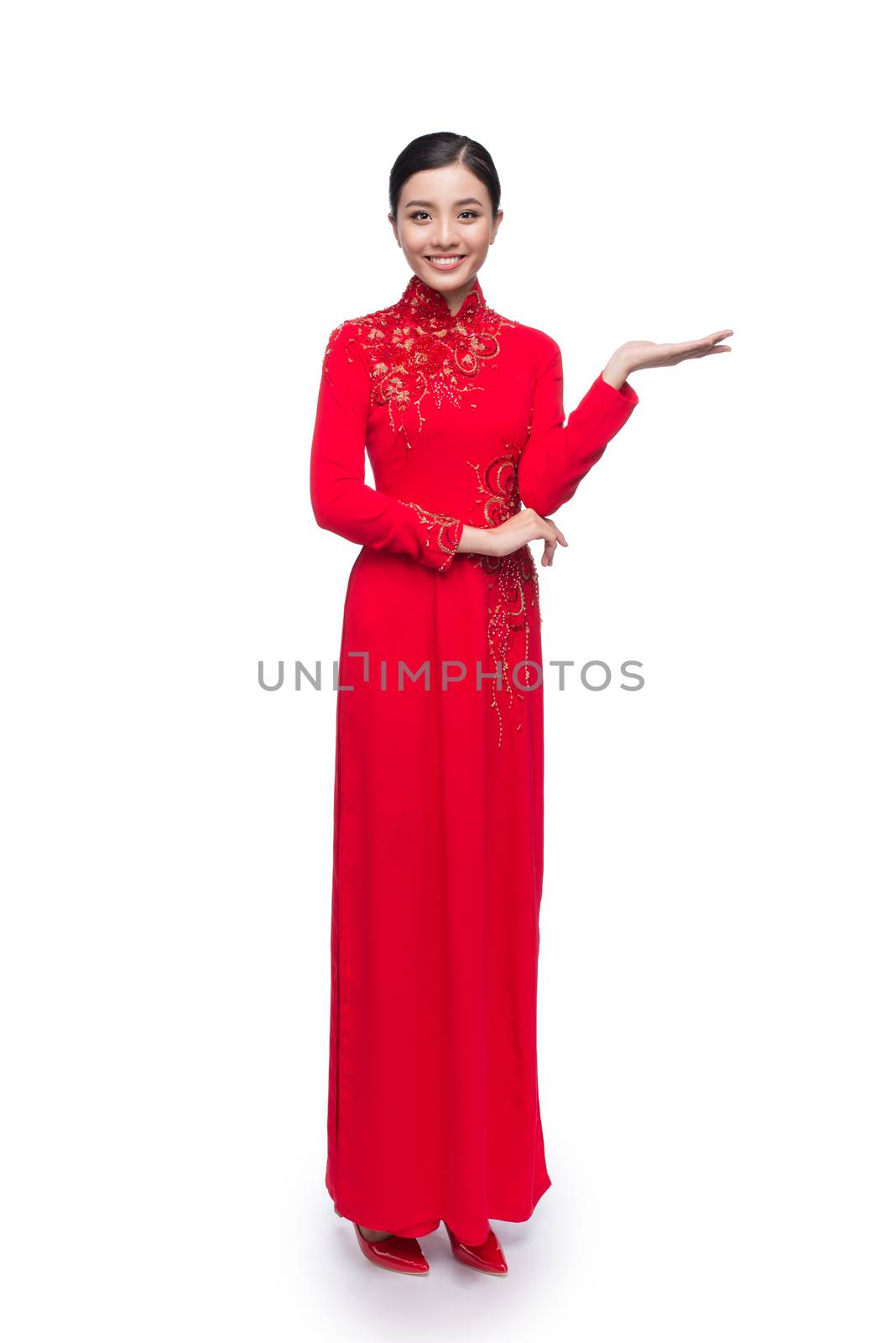 Full body of charming Vietnamese Woman in Ao Dai Traditional Dress present something