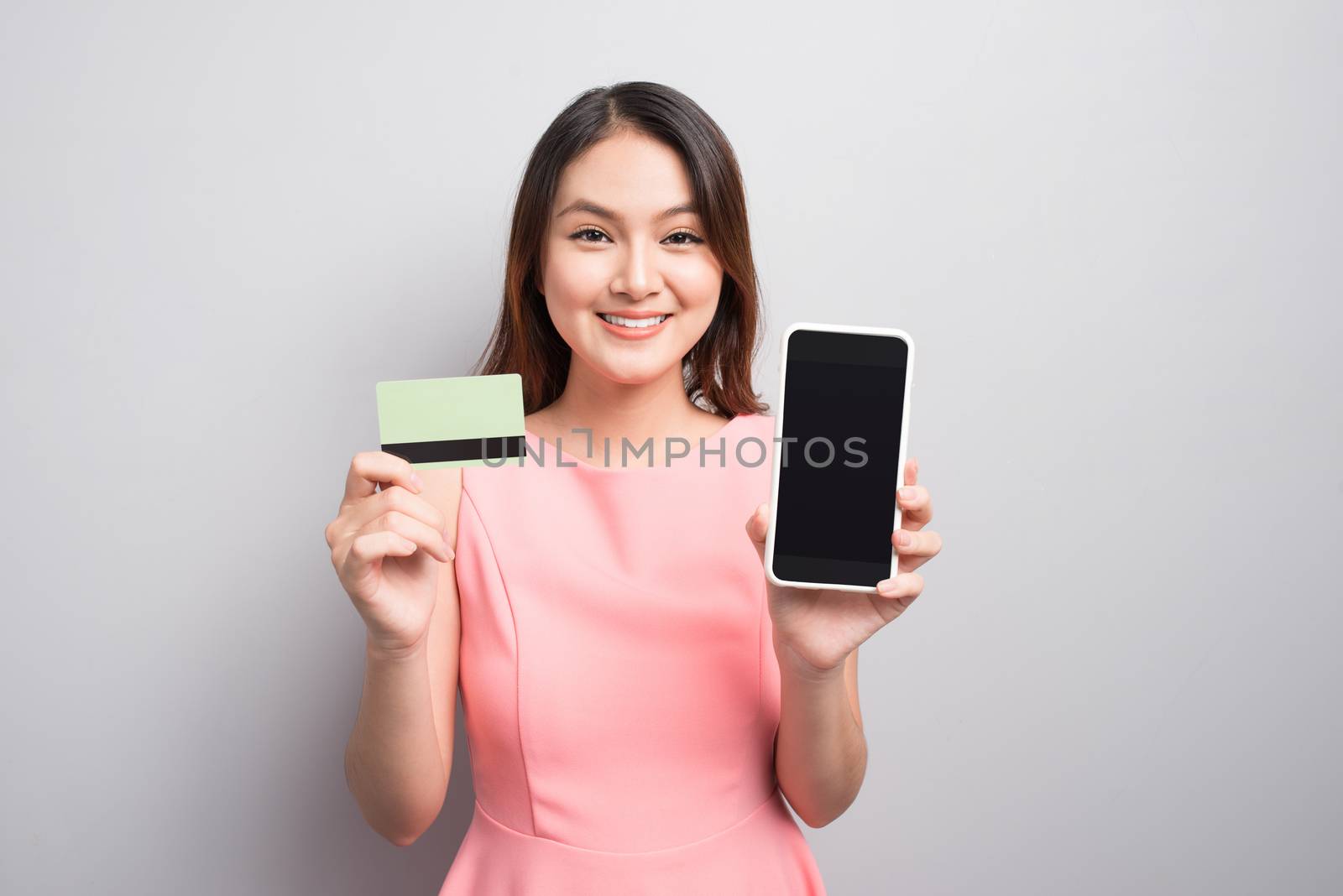 Charming asian woman hand holding smartphone and show credit car by makidotvn