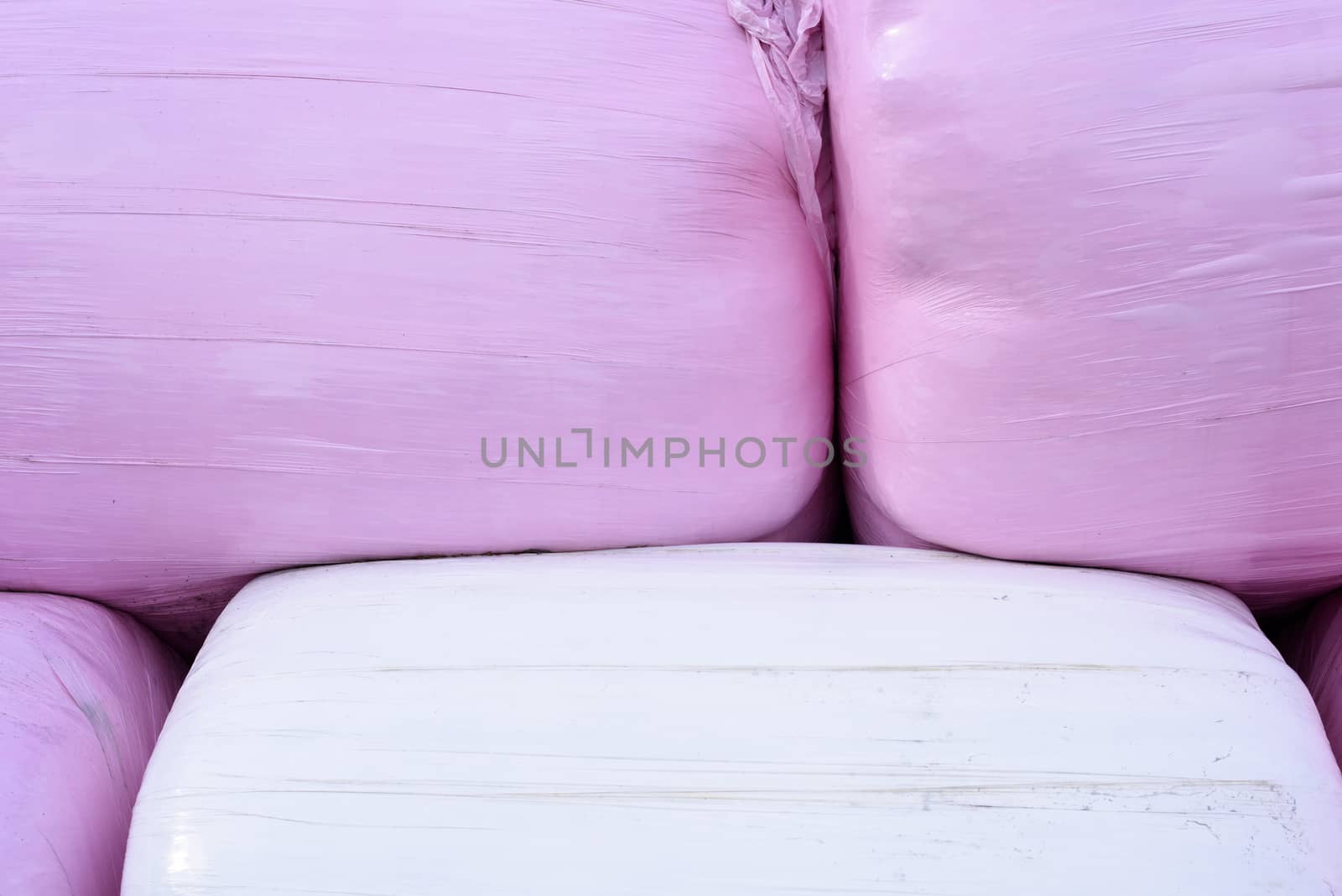 Bales of hay in pink and plastic wrapping.
