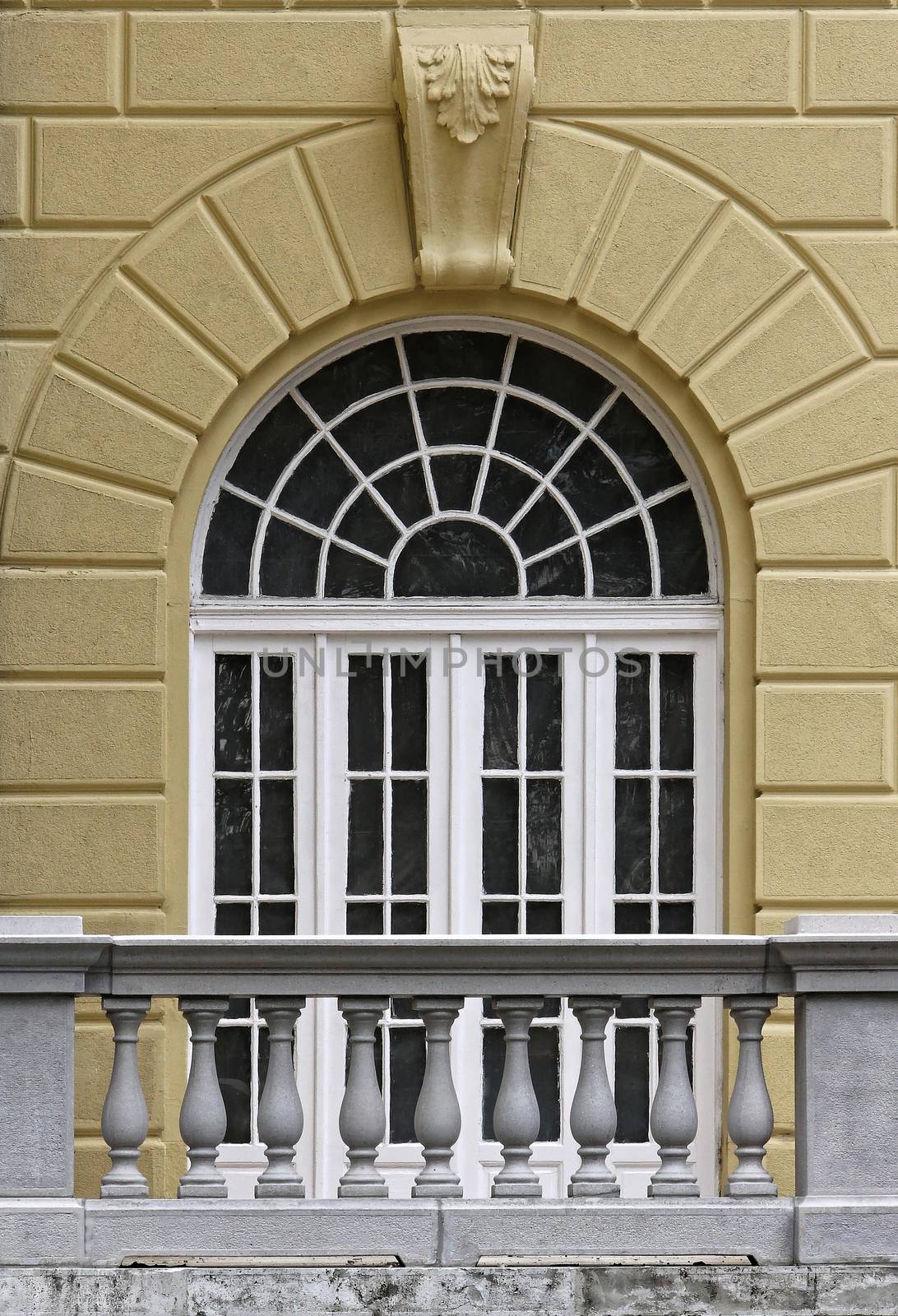 Vaulted mansion window with carved stone fence.