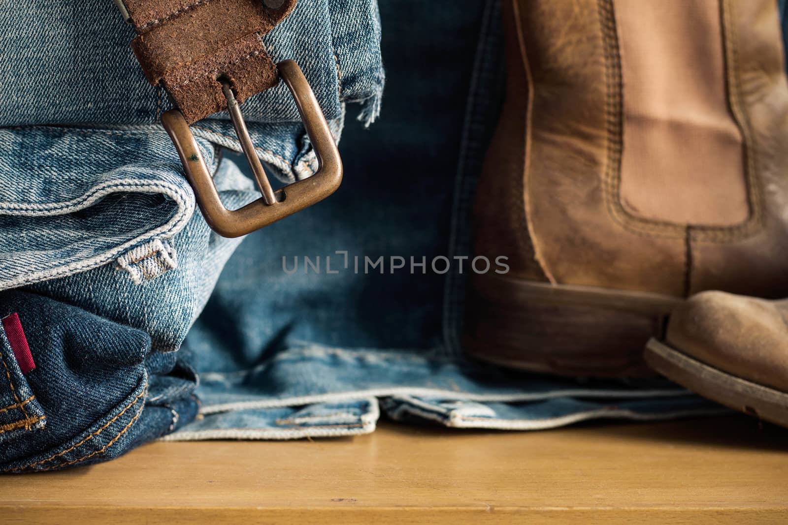 Old belt and Jeans on wooden floor.