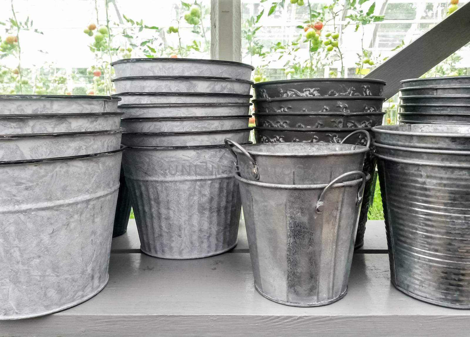 Simple metal flower pots on a shelf by anikasalsera