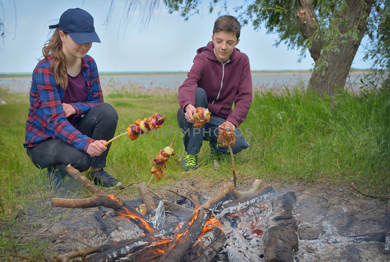 Teenagers enjoying together barbecue outdoors 