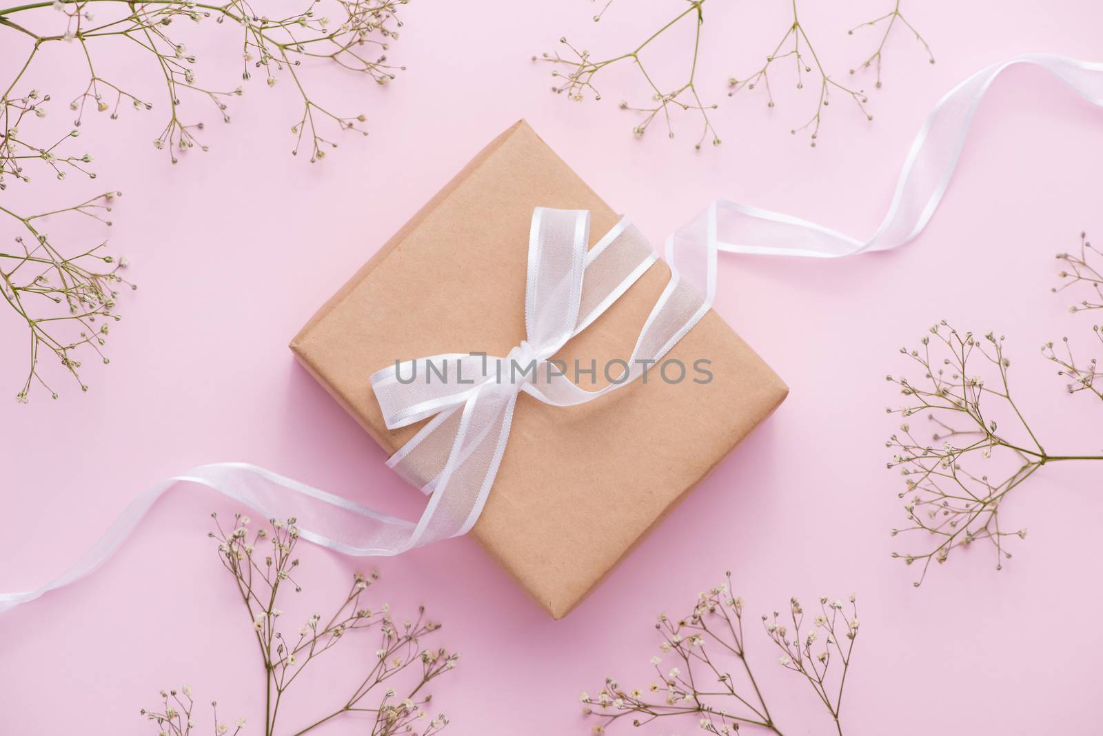 Kraft paper gift box tied with pink ribbon and white flowers for by makidotvn