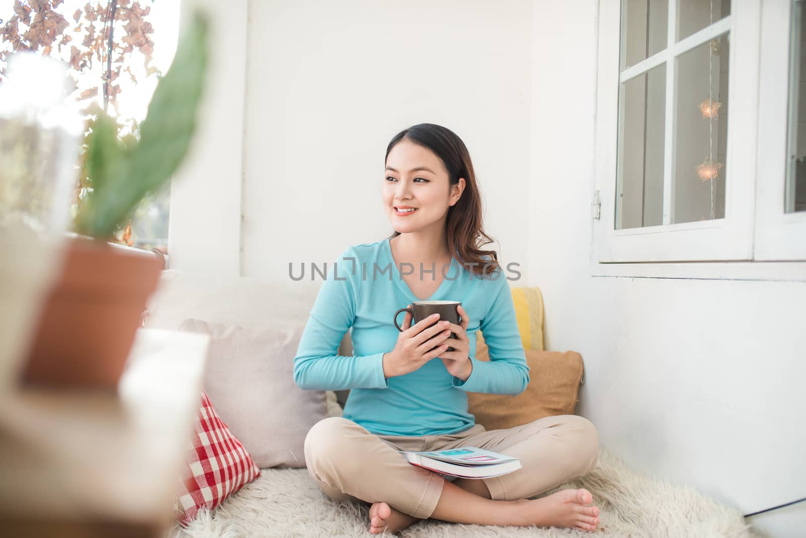 Portrait of young asian woman reading book at home