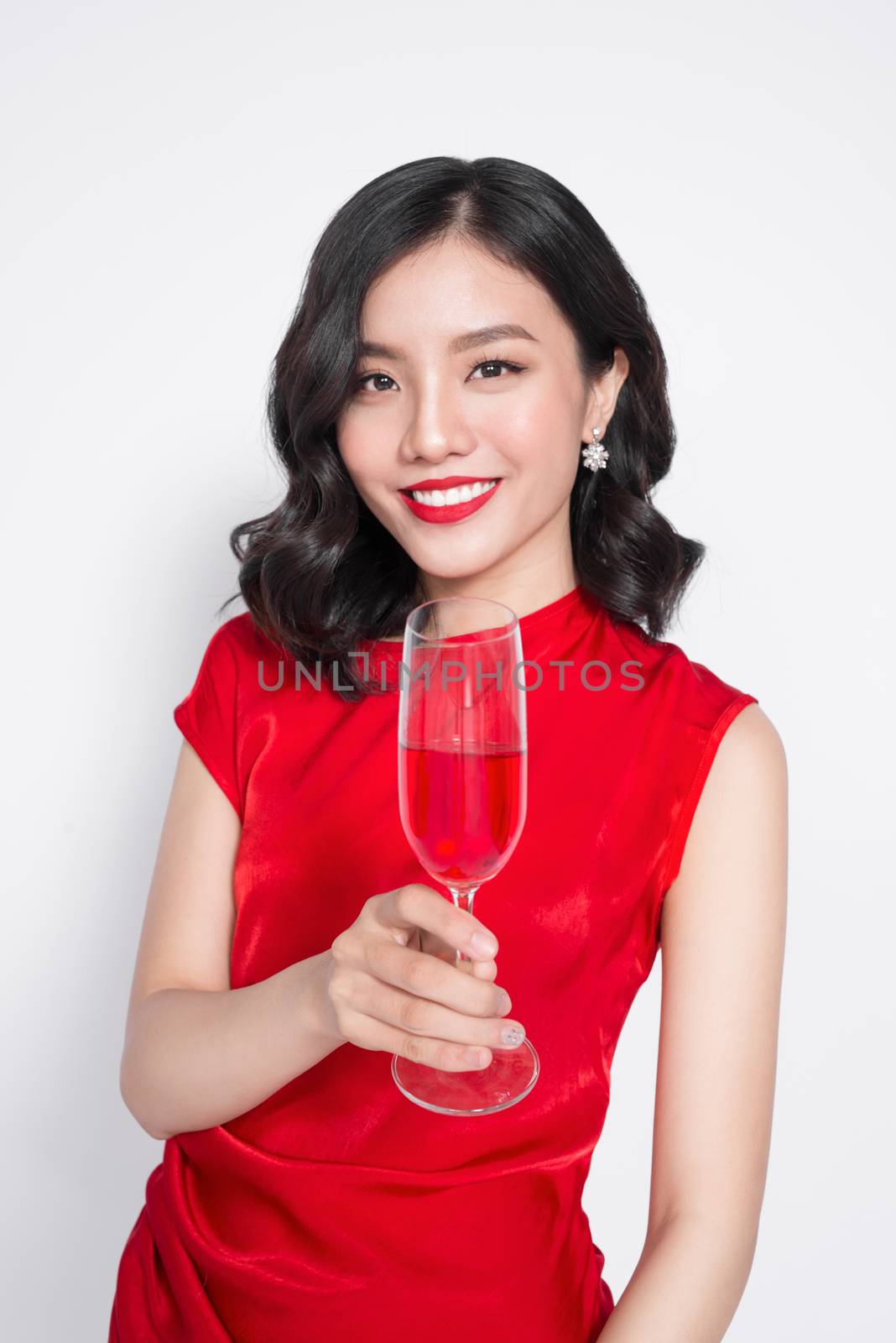 Beautiful asian girl in evening dress smiling holding glass of champagne