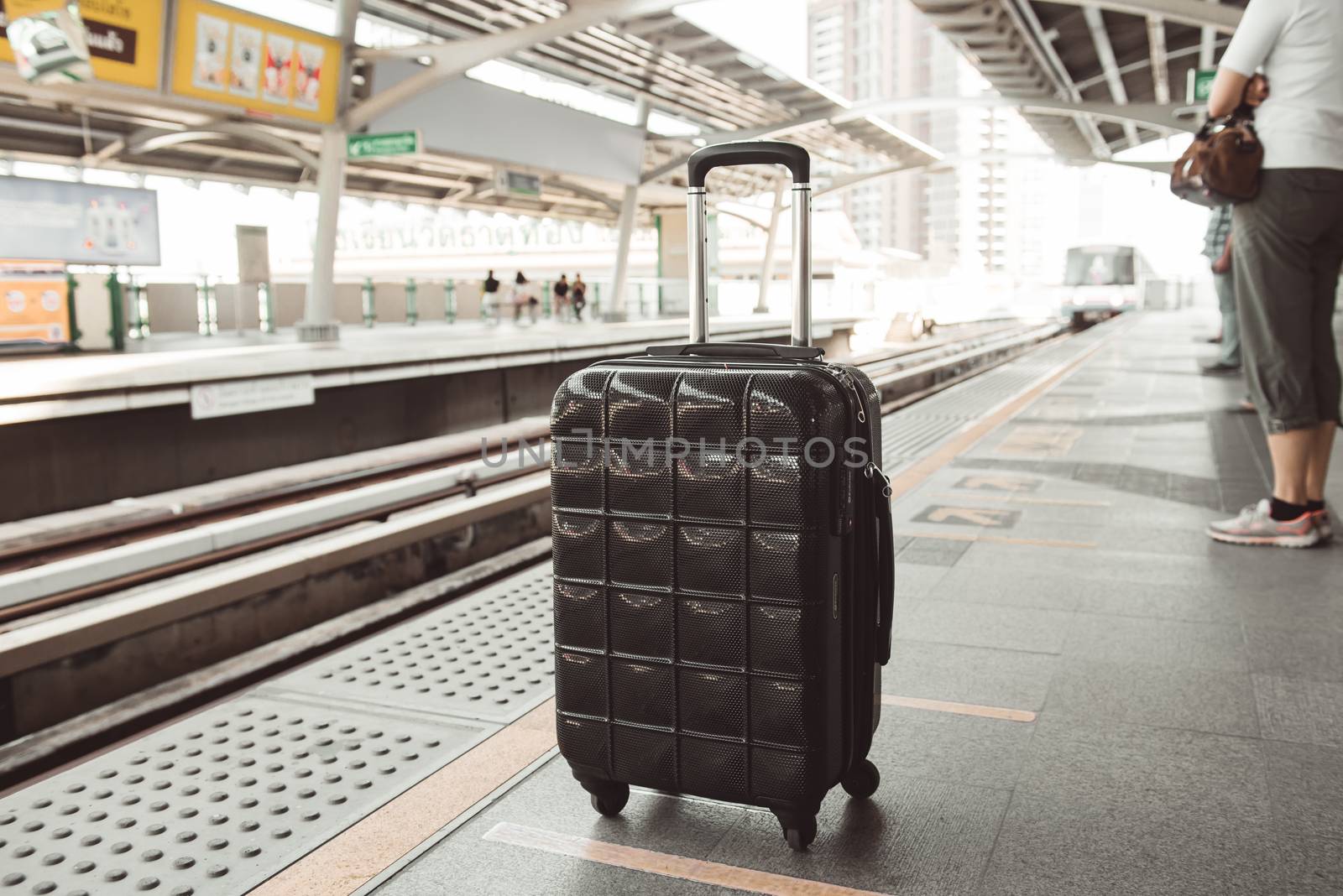 Black luggage waiting train in a station