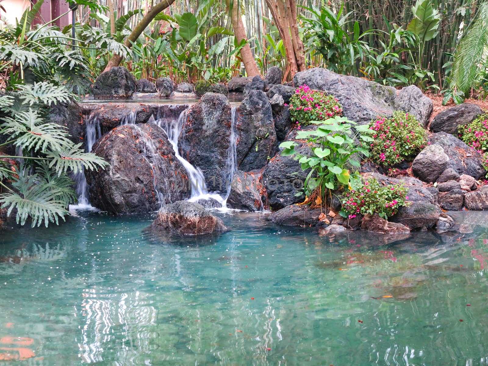 A small waterfall over rocks into pond